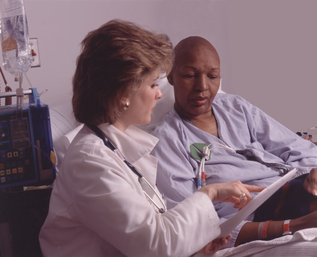 Health professional speaking with a chemotherapy patient at the bedside