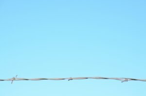 Barbed wire against a clear sky representing federal fraud enforcement