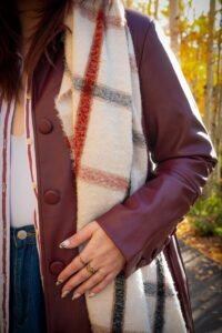Close-up of a layered autumn outfit with scarf and coat