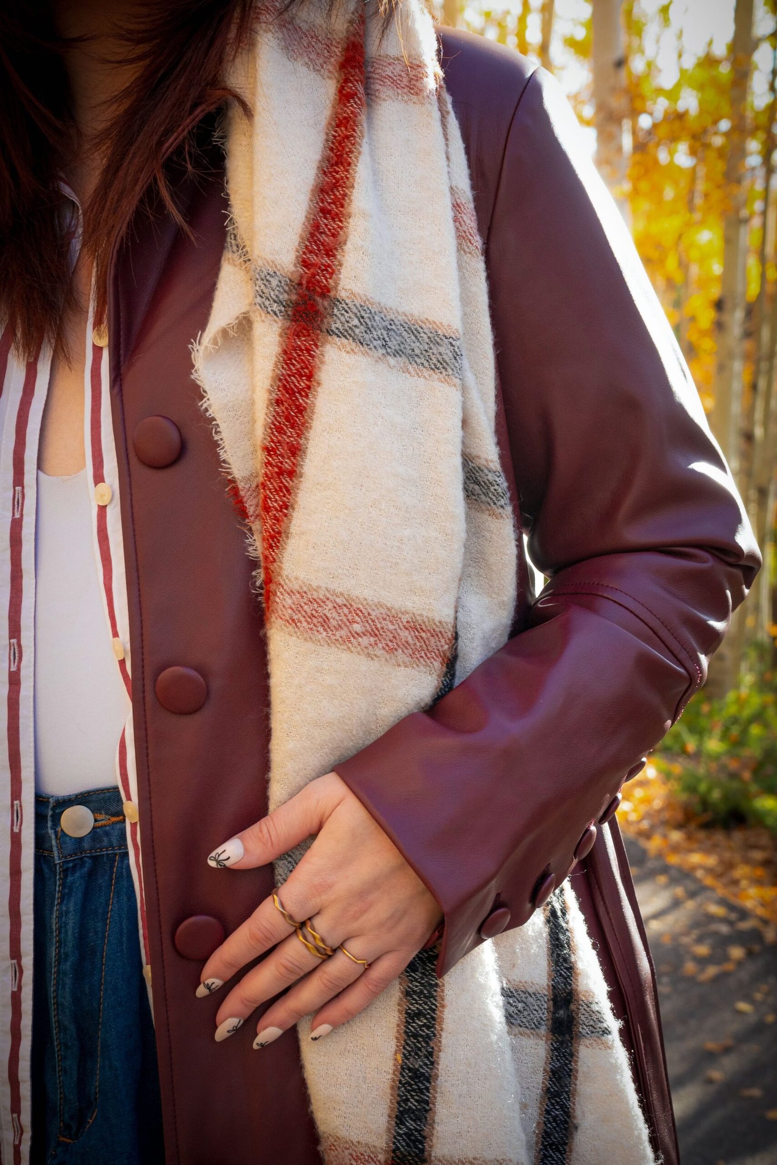 Close-up of a layered autumn outfit with scarf and coat