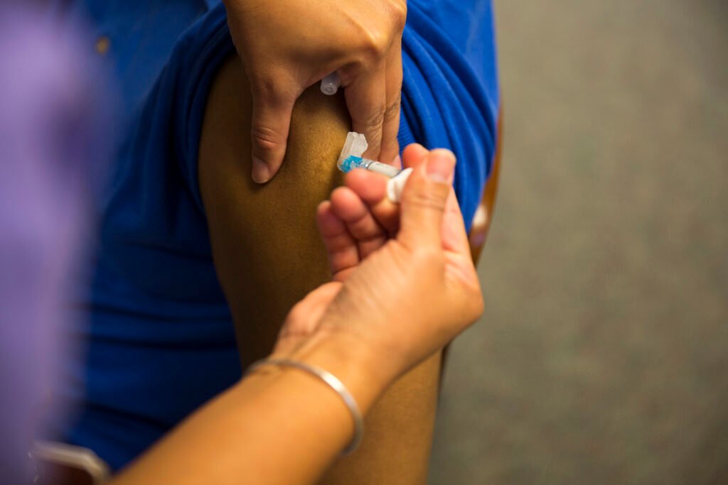 Healthcare professional administering a flu vaccine to a patient