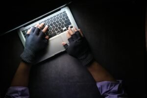 Person using a laptop in a dark setting representing digital technology and cyber investigations