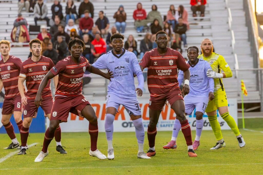 Soccer players competing on a field with spectators