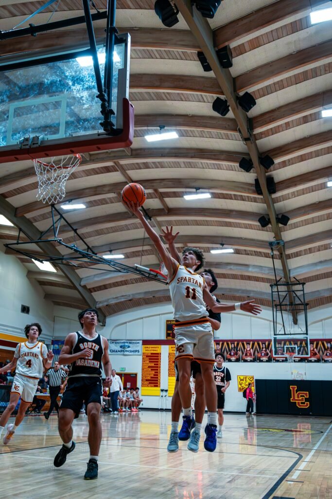 Basketball players competing near the basket