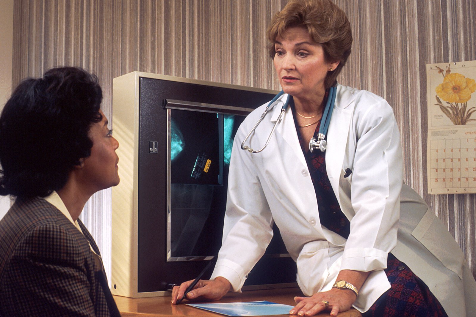Doctor speaking with a patient while reviewing medical imaging